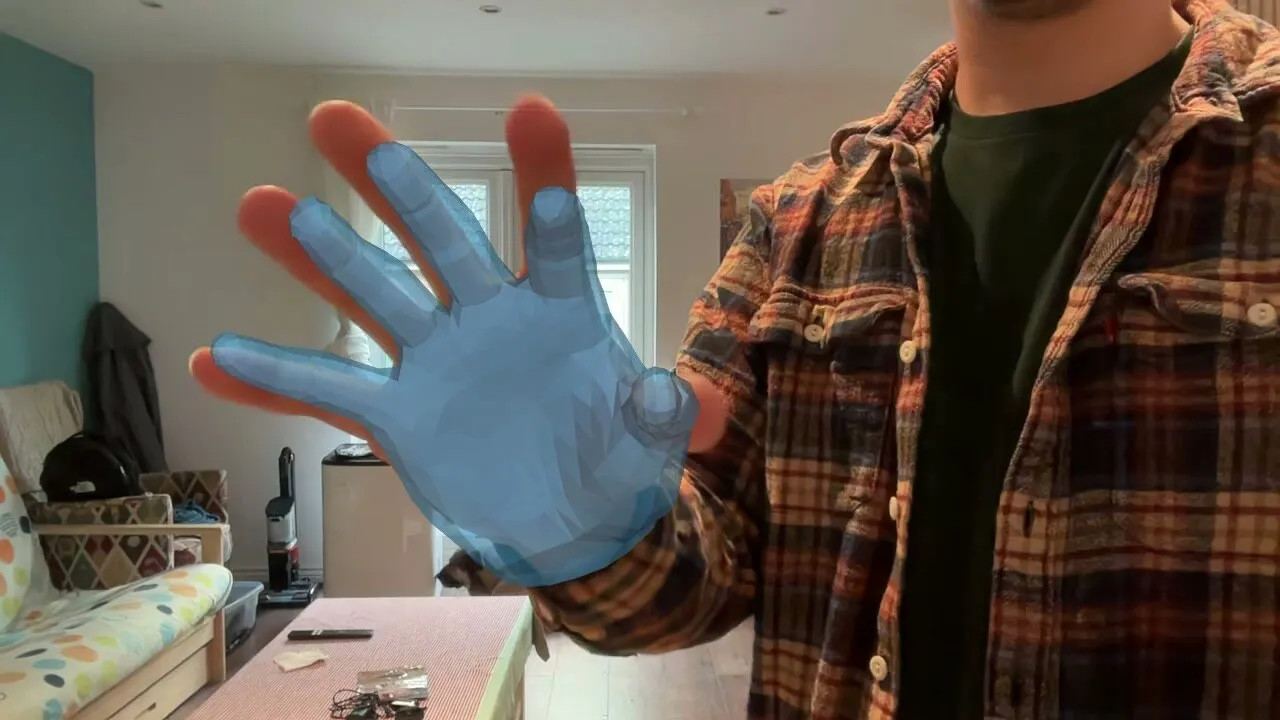 A blue 3D hand mesh overlaid on a webcam image of an open hand.